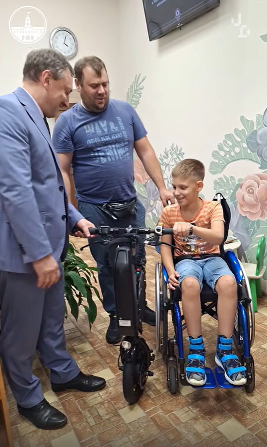 Семье из Колпинского района подарили электрическую приставку для инвалидной коляски сына