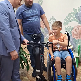 Семье из Колпинского района подарили электрическую приставку для инвалидной коляски сына